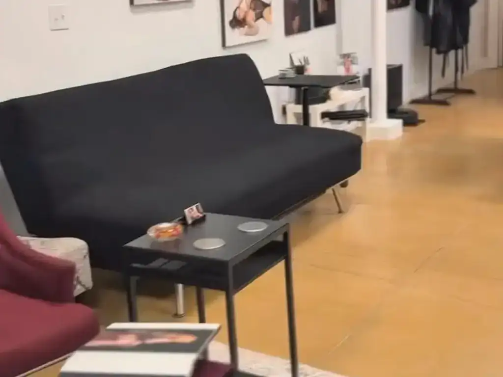 Cozy lounge area at Vanity Studio with black sofa and stylish decor.