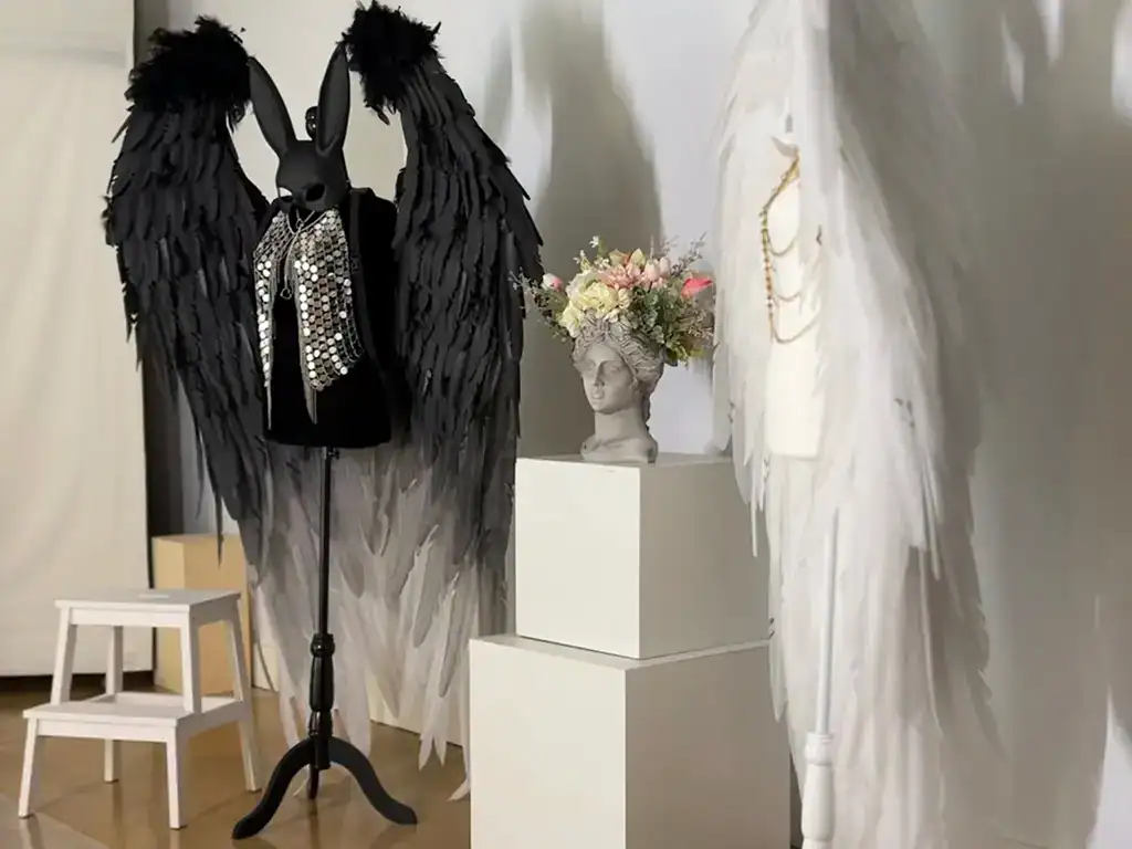 Black feathered angel wings costume with rhinestone accents for photoshoots and events.