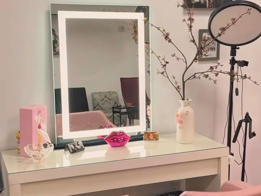 Vanity studio with mirror, flowers, and beauty accessories for professional makeup.
